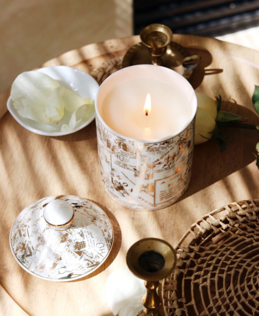 Speakeasy Ceramic Candle on a wooden table with the candle lid, flowers, brassware, and ceramics.