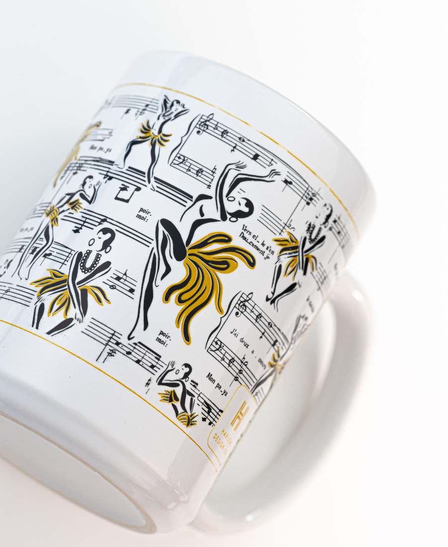 White mug with decorative band featuring black and gold dancer illustrations on a white background