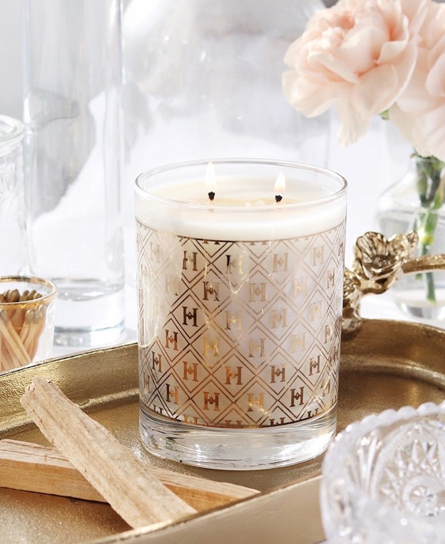 22k Gold Speakeasy Candle on a gold tray with flowers and glassware.