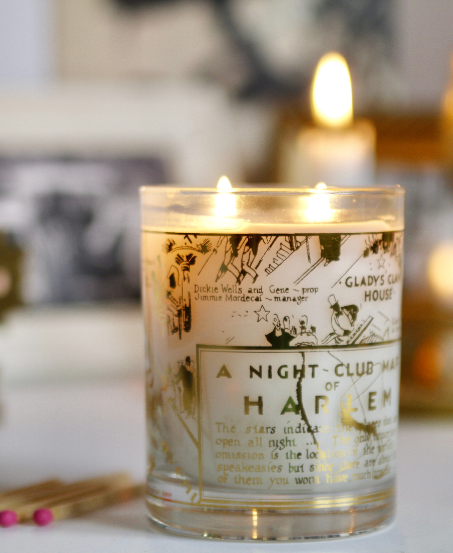 22k Gold Nightclub Map Savoy Candle on a white table with matches.