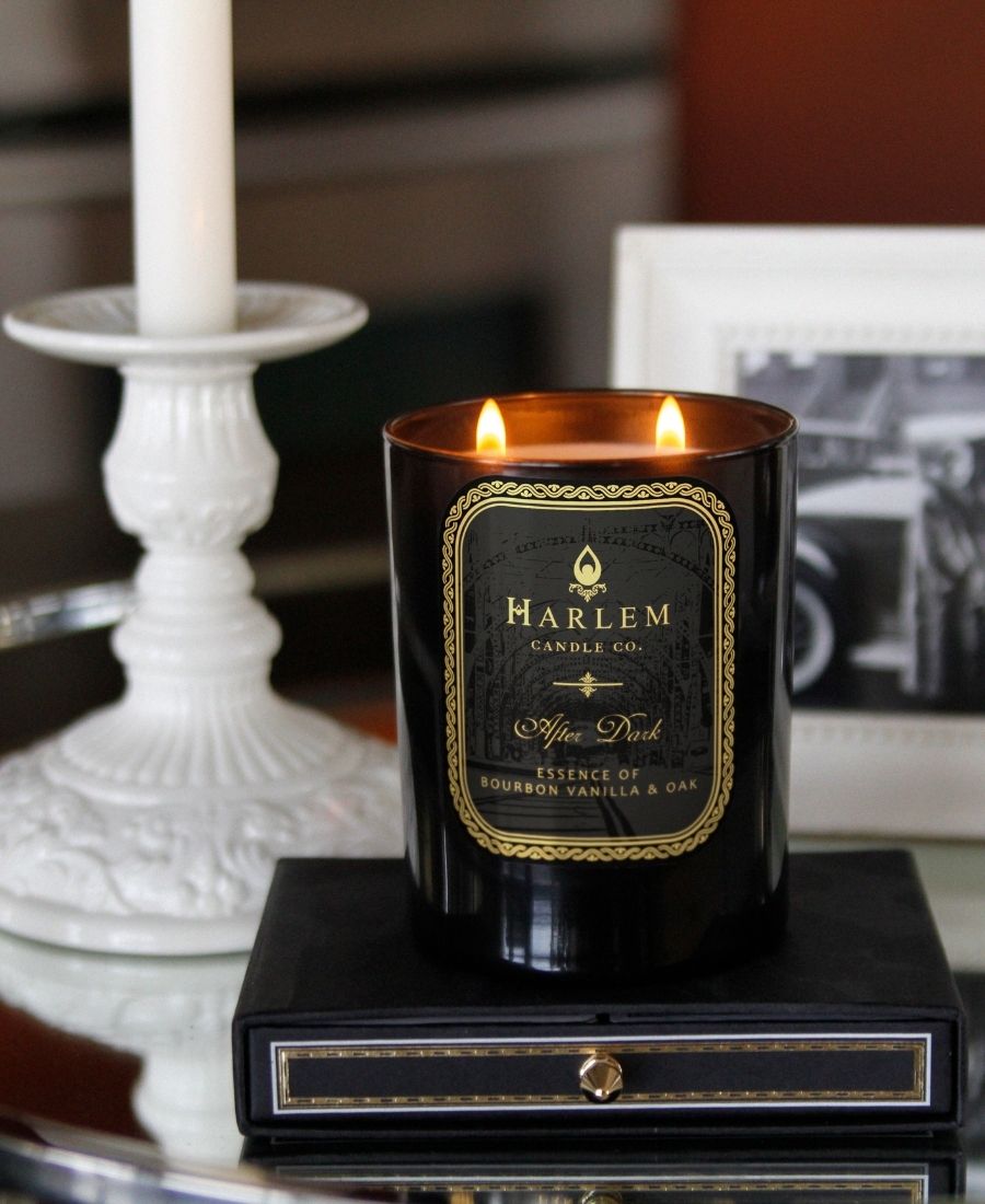 After Dark Candle on a black box with a white candle holder and framed photograph.