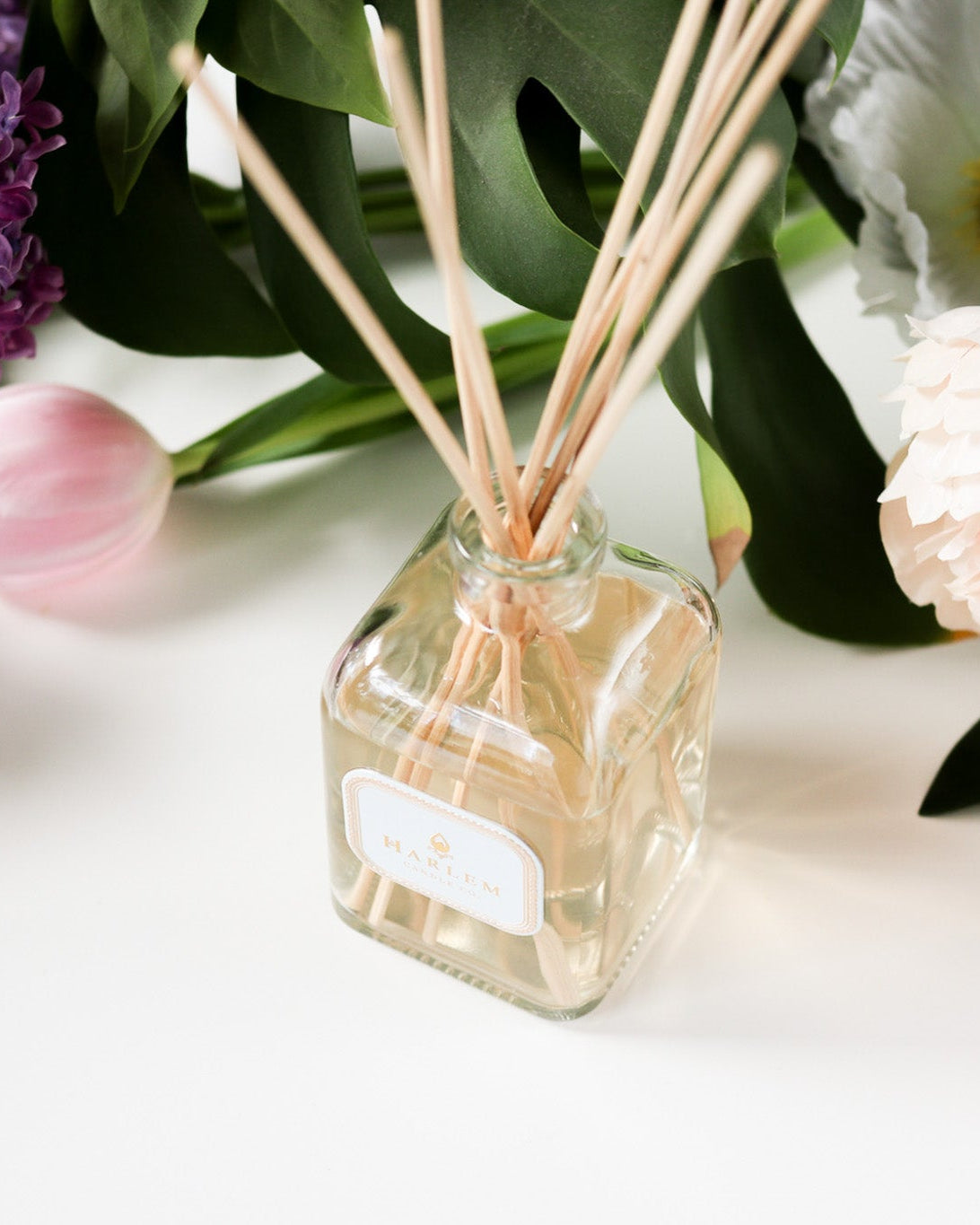 This is a horizontal image of the clear glass "Dream" Botanical Diffuser with purple and pink flowers.