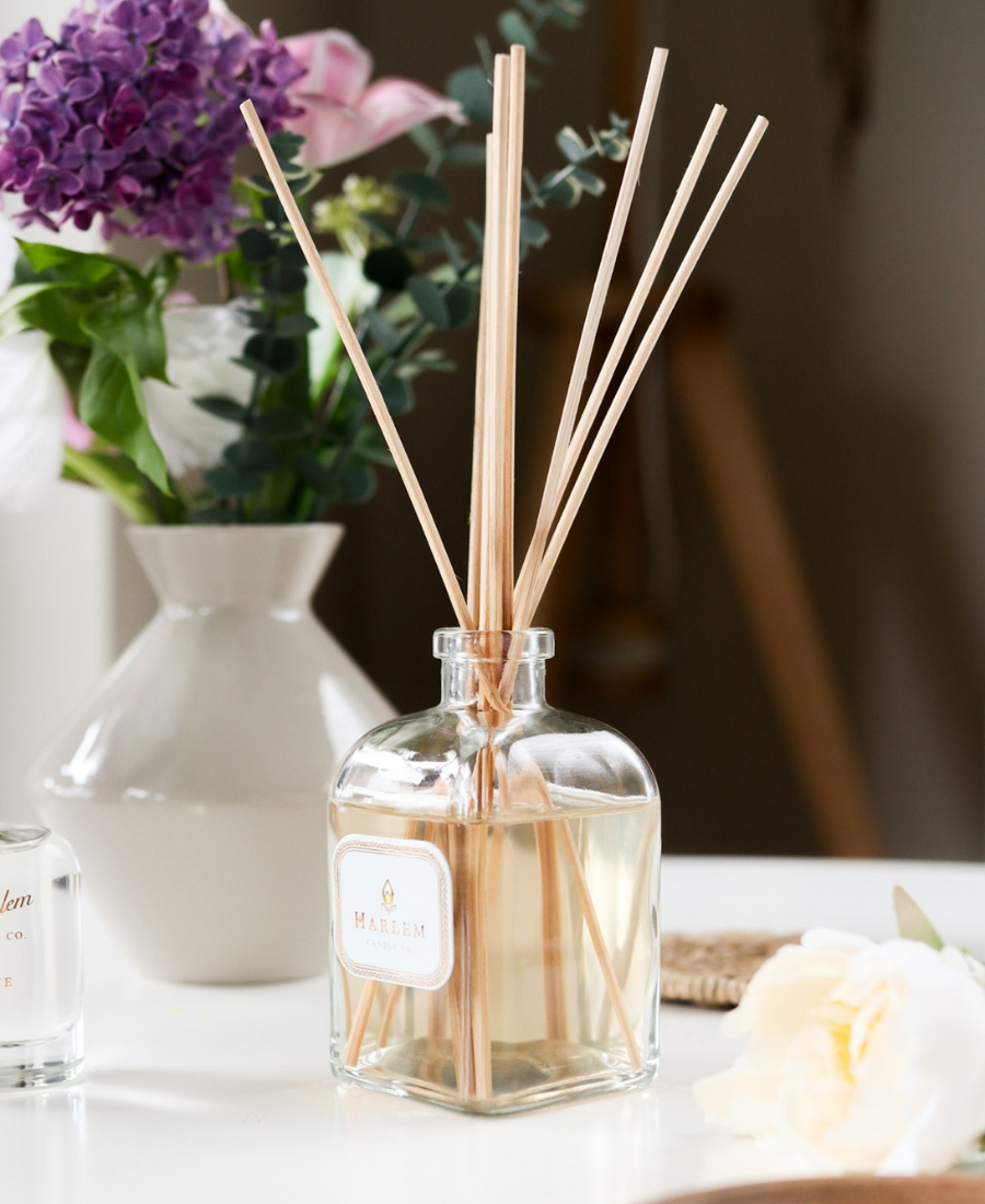 Joy Reed Diffuser on a white table with flowers.