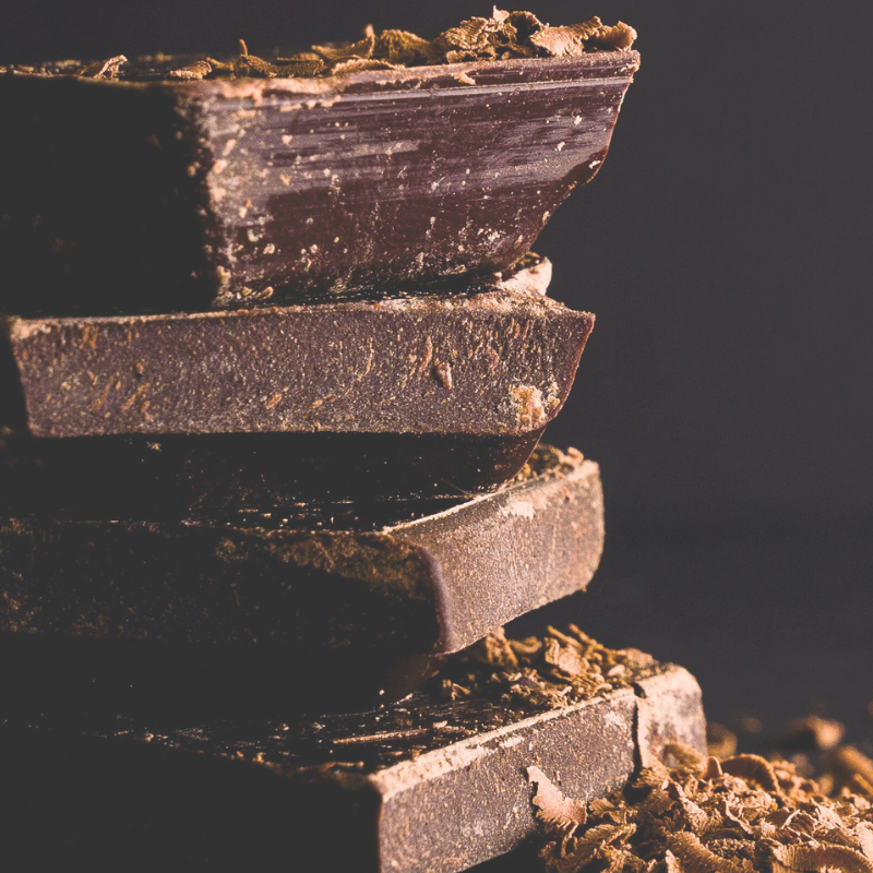 This is an image of a stack of dark chocolate with shavings.