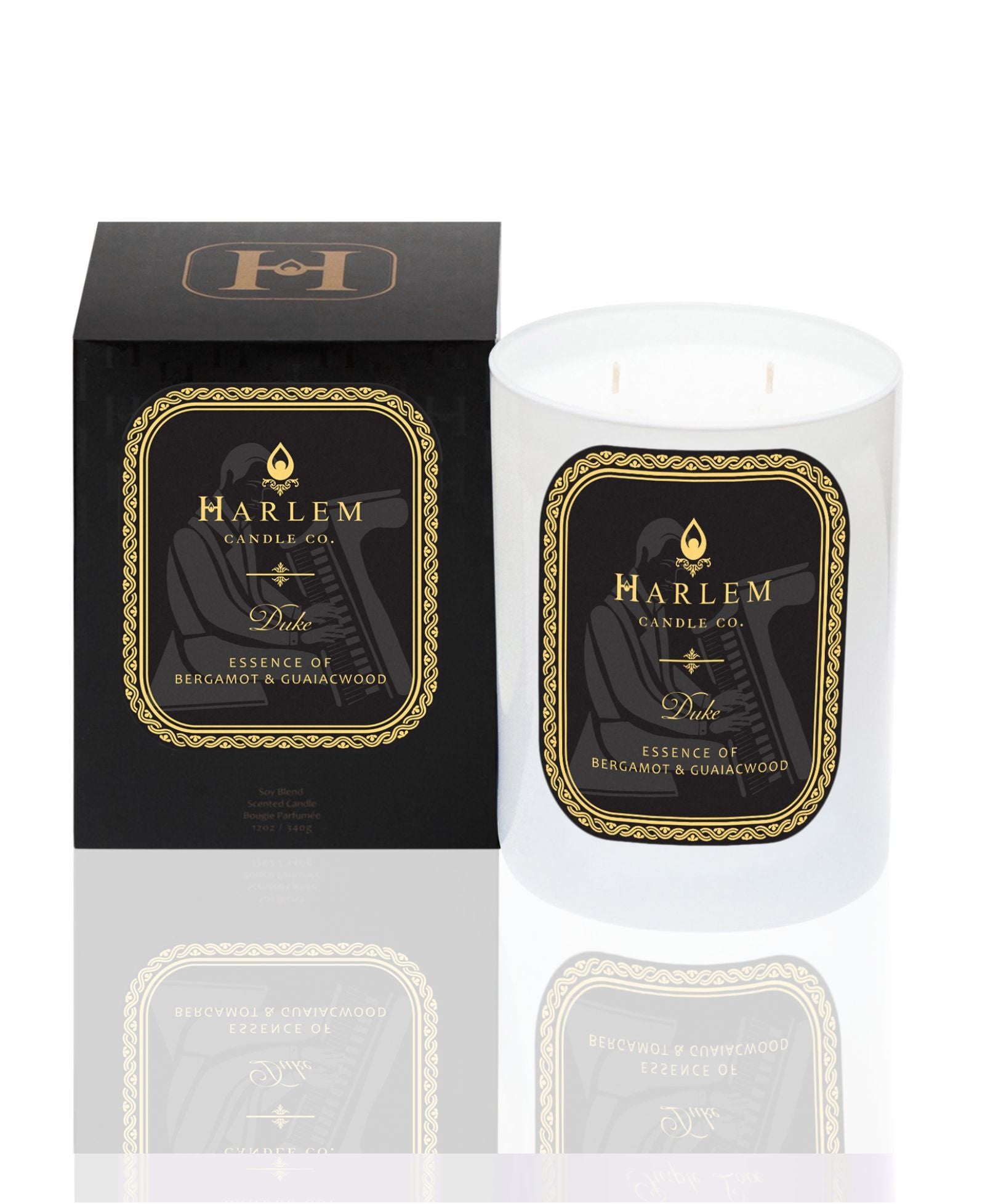 White 11 oz Duke candle with gold and Black label. This candle has 2 wick. It is pictured next to it's decorative candle box.