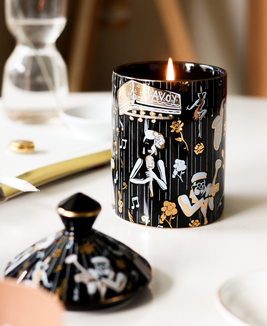 Duke Ceramic Candle on a white table next to the lid, a book, and glassware.