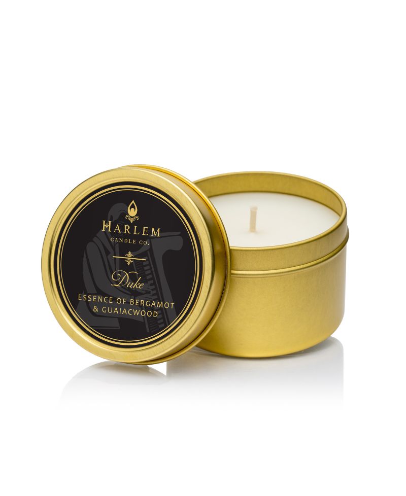 Picture of the Duke Travel candle. It is in a gold tin with a black label on the top.