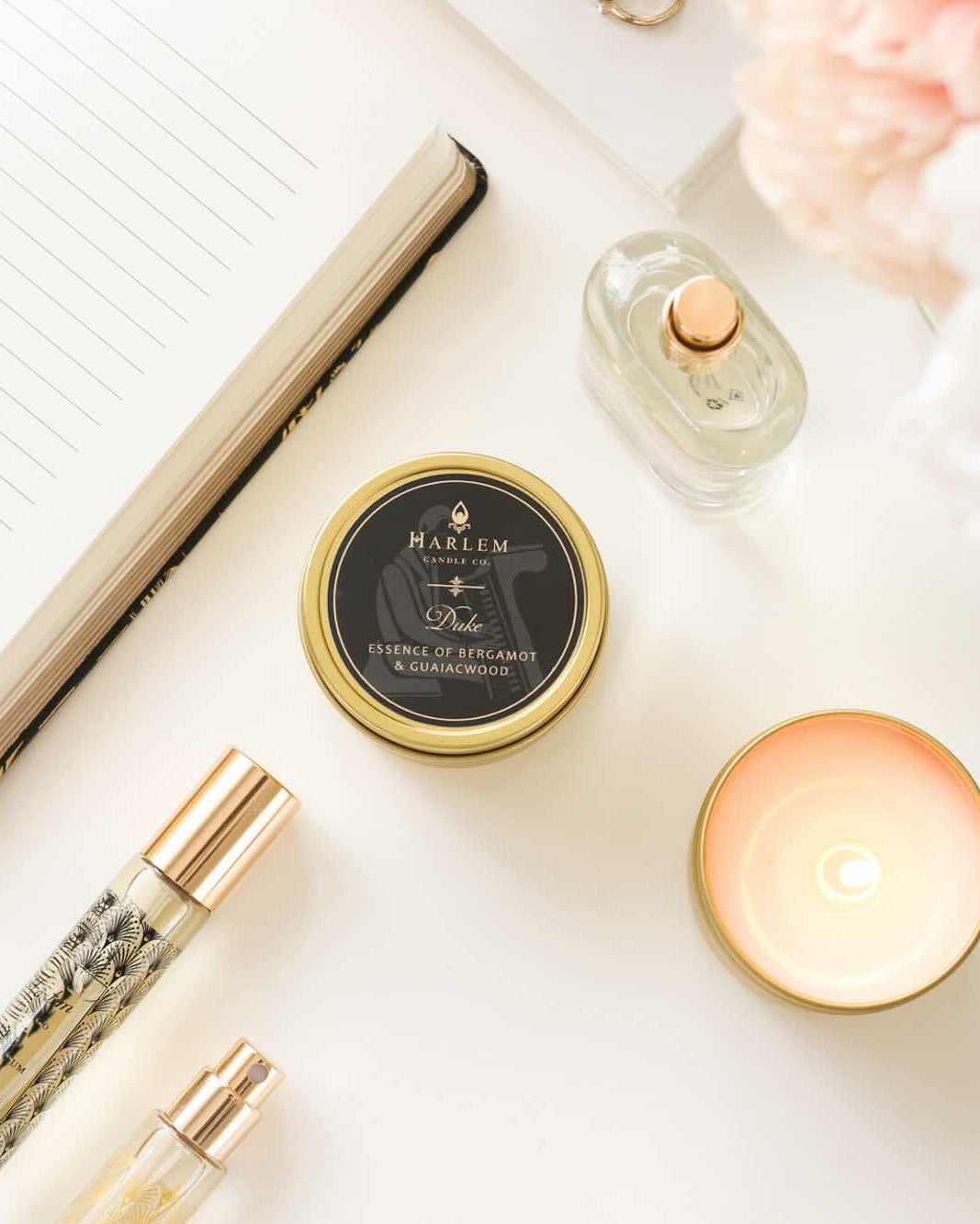 This is a lifestyle image of the Duke travel candle. There are also Harlem perfumes and a Harlem Design co journal.