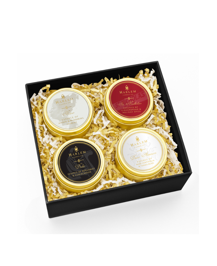 This is an image of the Holiday Travelers edit set of 4 candles including Nina, St. Nicholas, Duke and Deux Amours showing in a box with gold and white crinkle paper.