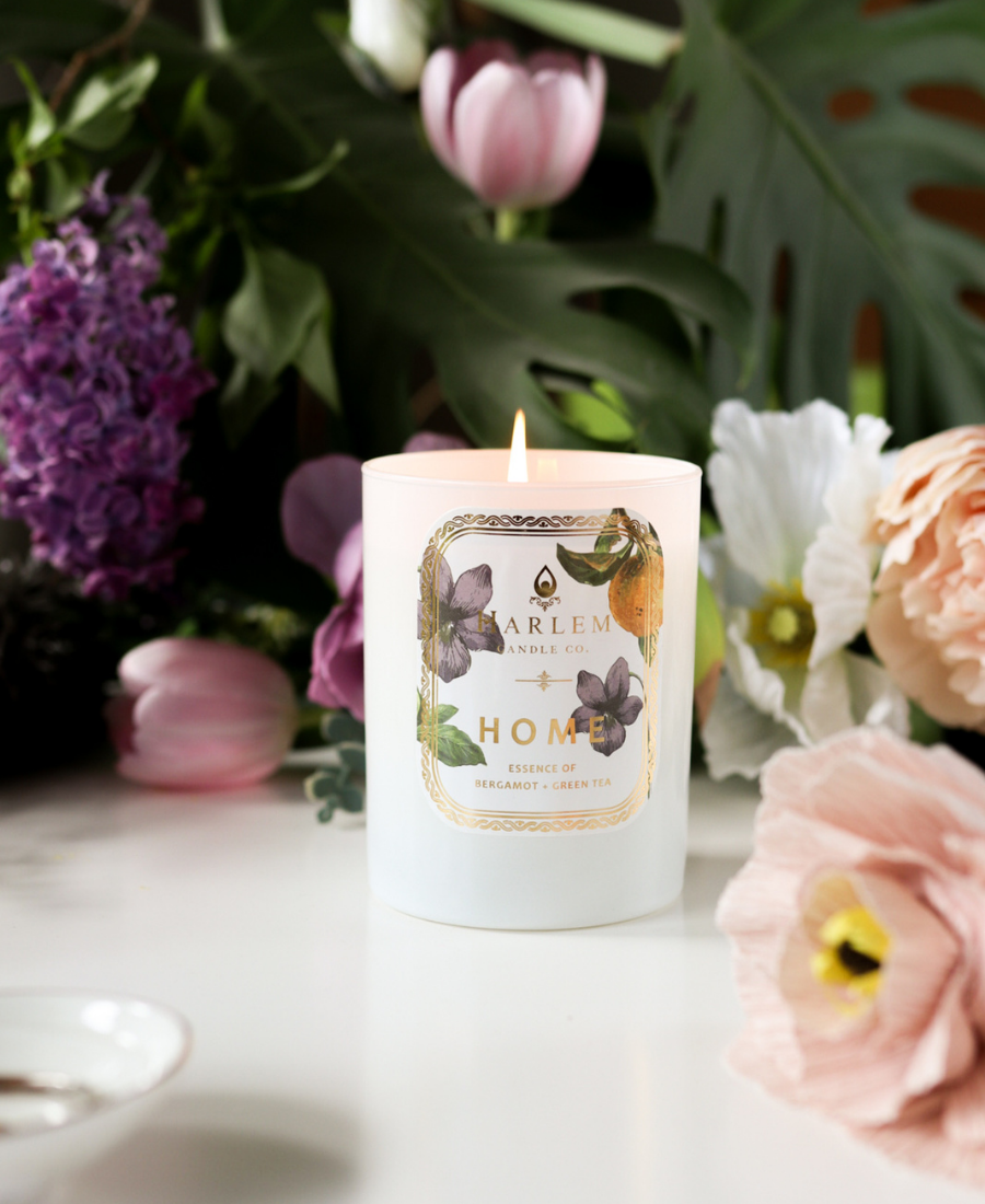 Home Candle on a white table with flowers.