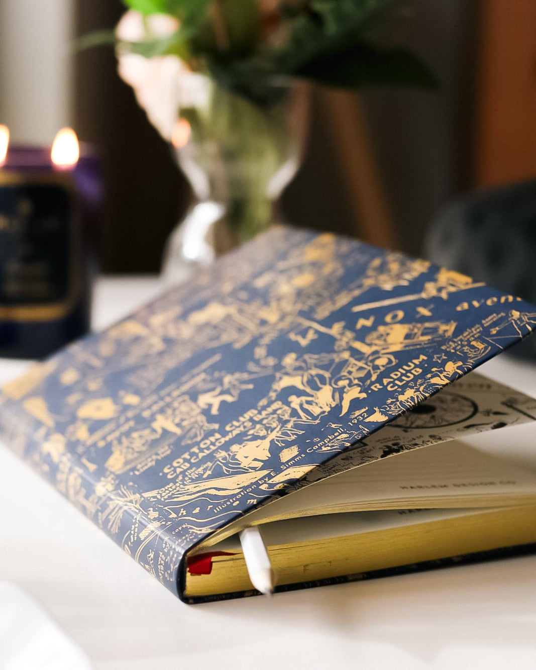 This is an image of our navy and gold nightclub map of Harlem journal featured next to our Langston candle with the flames illuminated