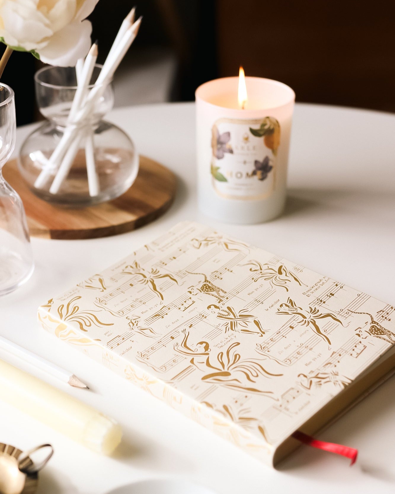 This is an image of our cream and gold, Josephine journal picture next to our home candle with the flame illuminated