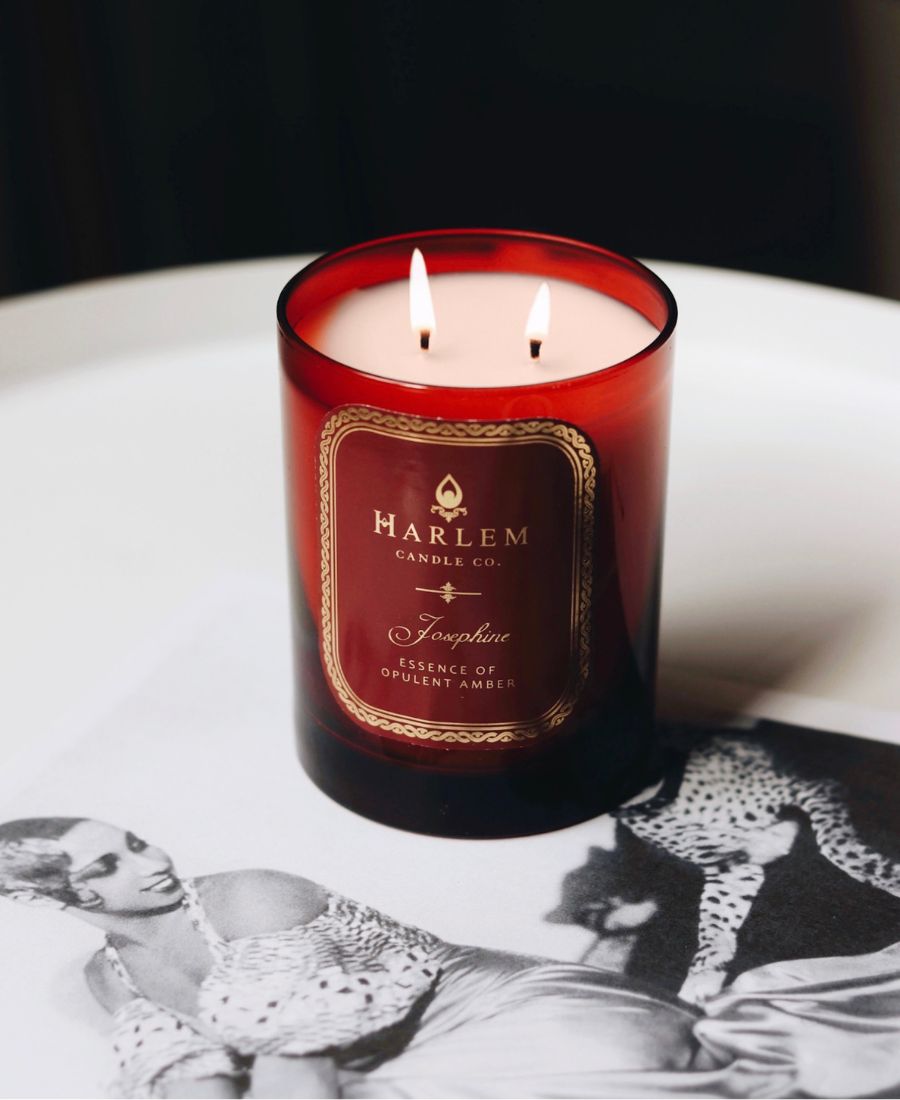 Josephine Candle with 'Harlem Candle Co' label on a white surface with black and white photos in the background.