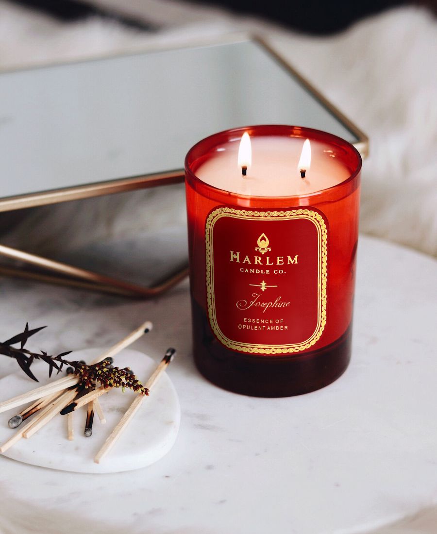 Red Josephine candle with 'Harlem Candle Co.' label on a marble surface.
