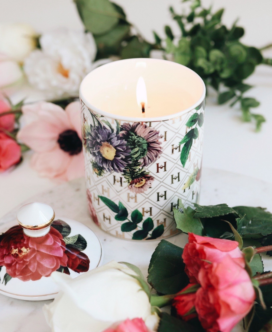 Lady Day Ceramic Candle on a white table with flowers and the lid.