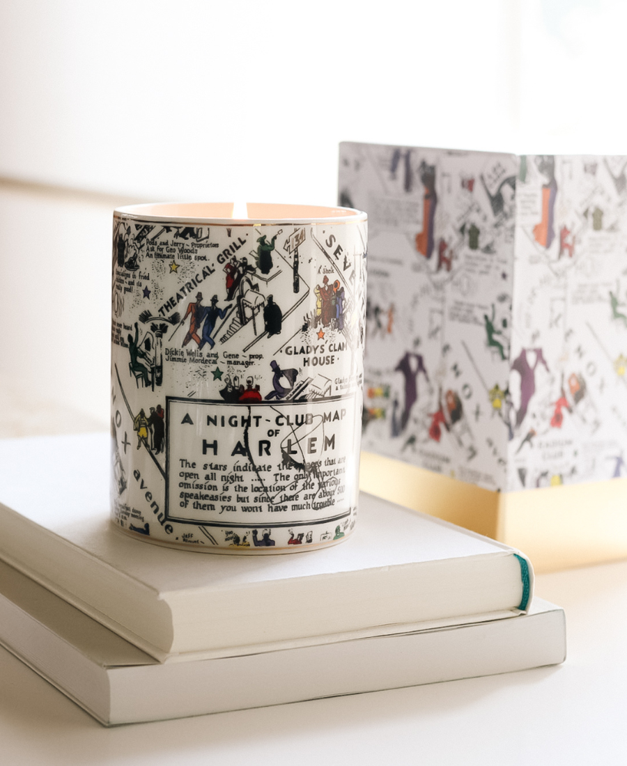 Langston Ceramic Candle on a white table with box and white books.