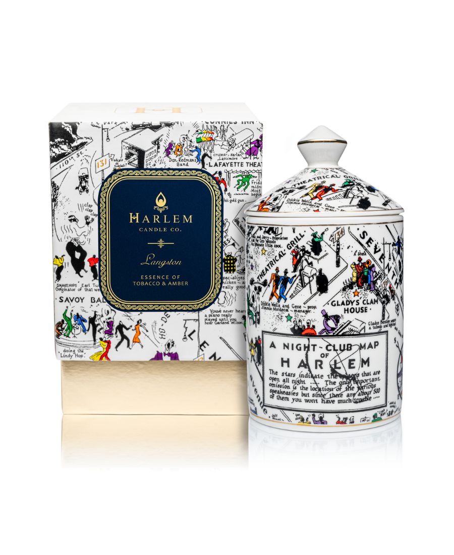 This is an image of our night club map of Harlem candle in black-and-white with pops of color. This candle has a dome lid and is Fragrance with the Langston scent. In this image, it is featured next to it decorative box with the blue and gold Langston label.
