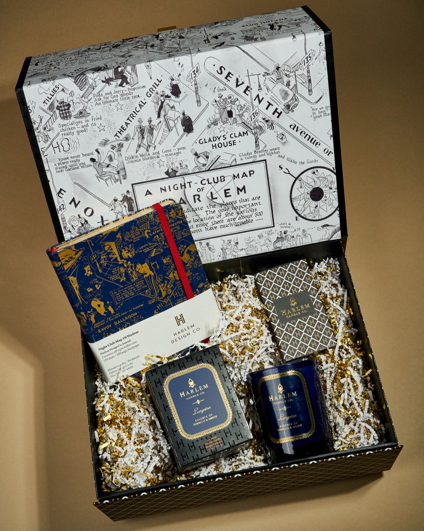 This is an image of our Langston Dreams gift box which includes the Langston candle, blueThis is an image of our Langston stories gift box which includes the Langston candle, blue and gold nightclub map of Harlem, Journal, and ourThis is an image of our Langston stories gift box which includes the Langston candle, blue and gold nightclub map of Harlem Journal, and our elegant art deco matches.