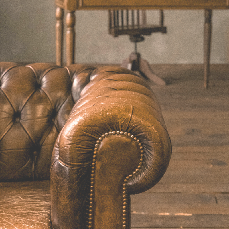 This is an image of a leather couch on a wooden floor.