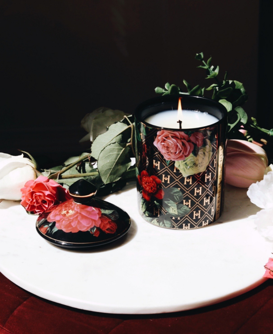 Love Ceramic Candle on a white table with flowers and the lid.
