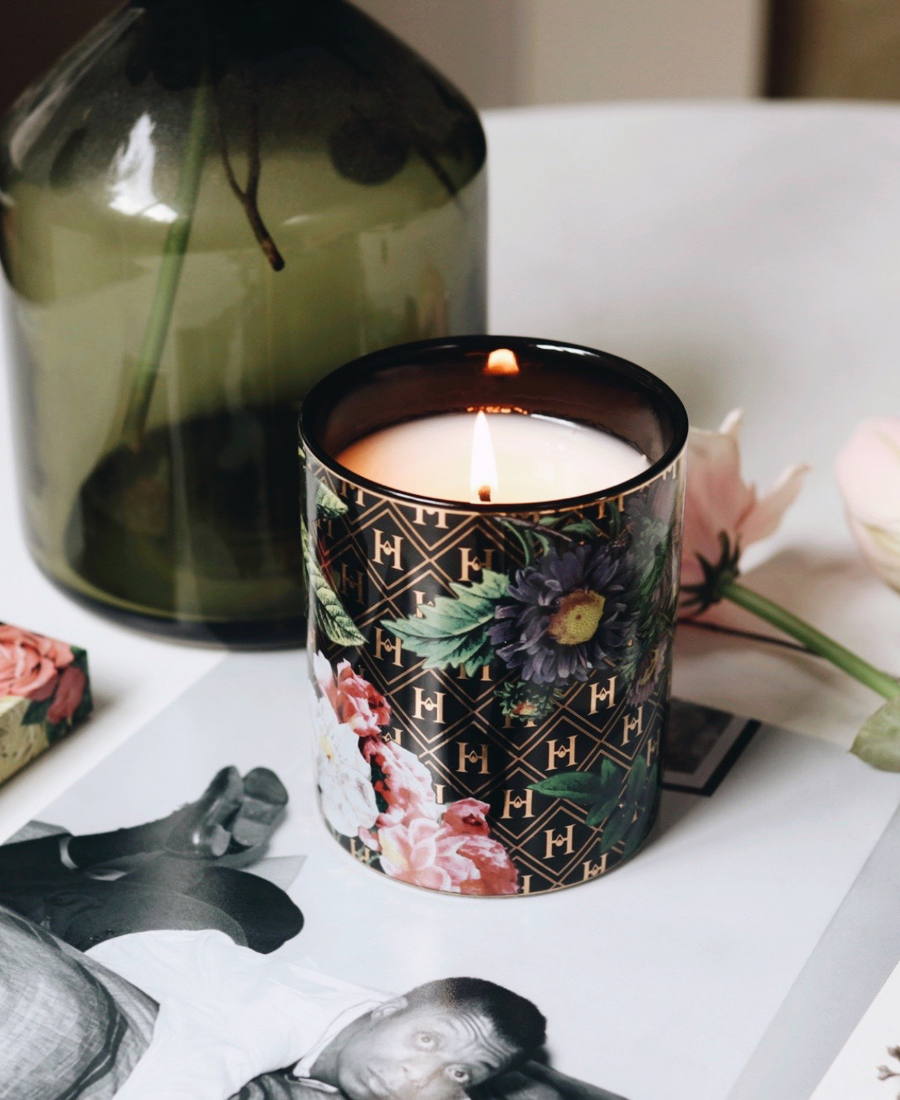 Love Ceramic Candle on a white table with flowers, a green vase, and a vintage photograph of James Baldwin.