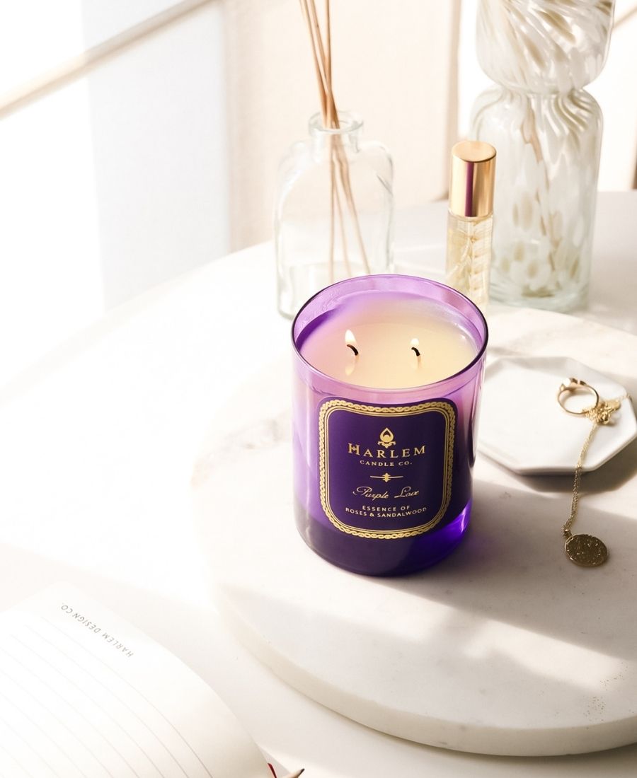 Purple Love Candle on a marble table with glassware.