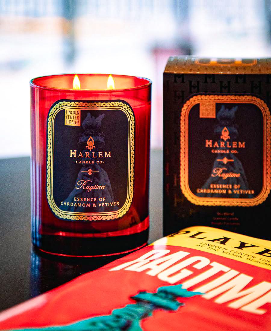 Harlem Candle Co. candle with packaging and a playbill titled Ragtime on a table.