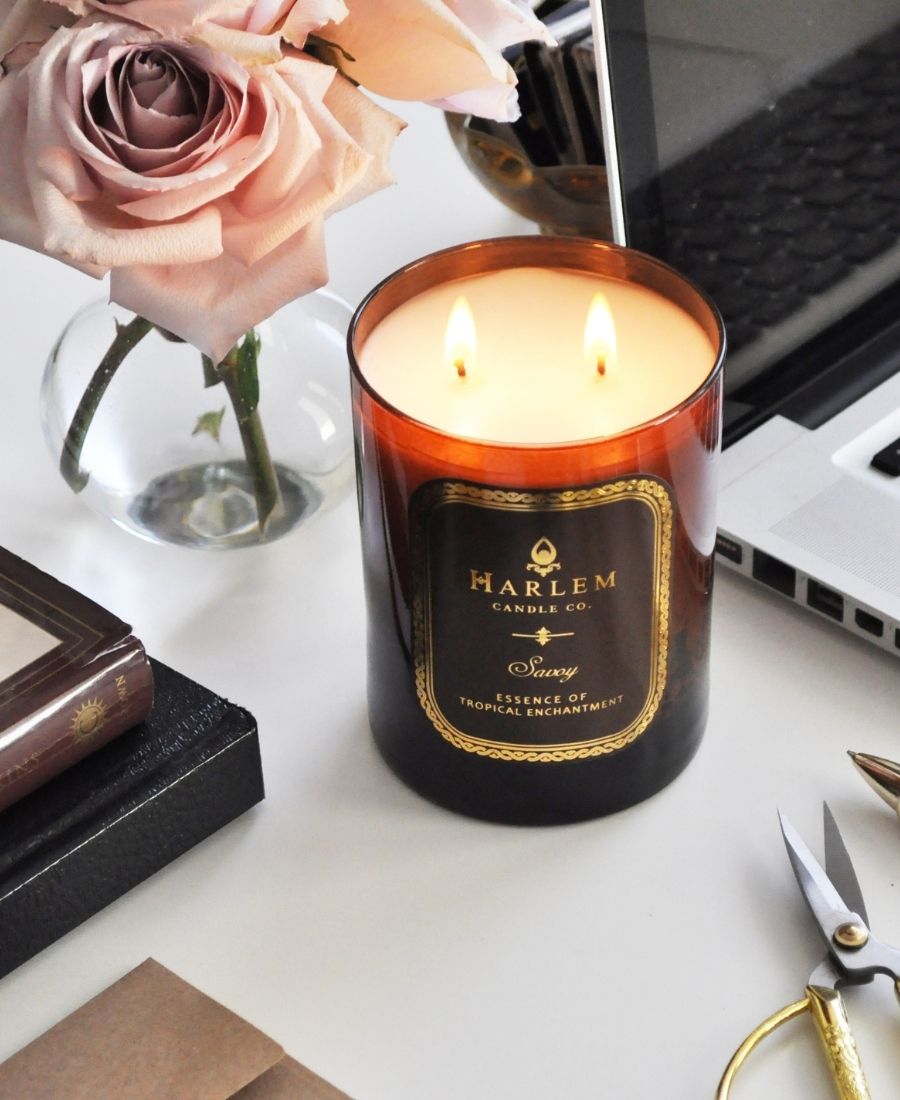 Savoy Candle on a white table with a laptop and flowers.