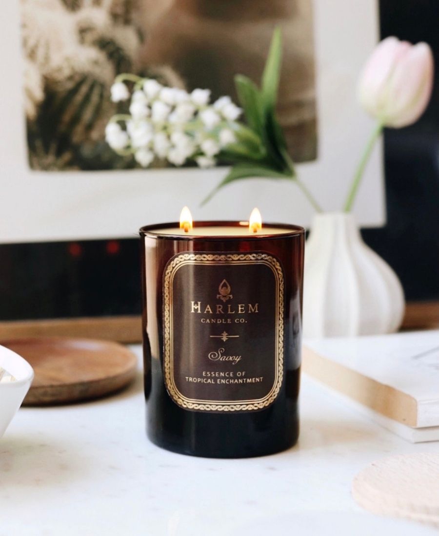 Savoy Candle on a white table with flowers.