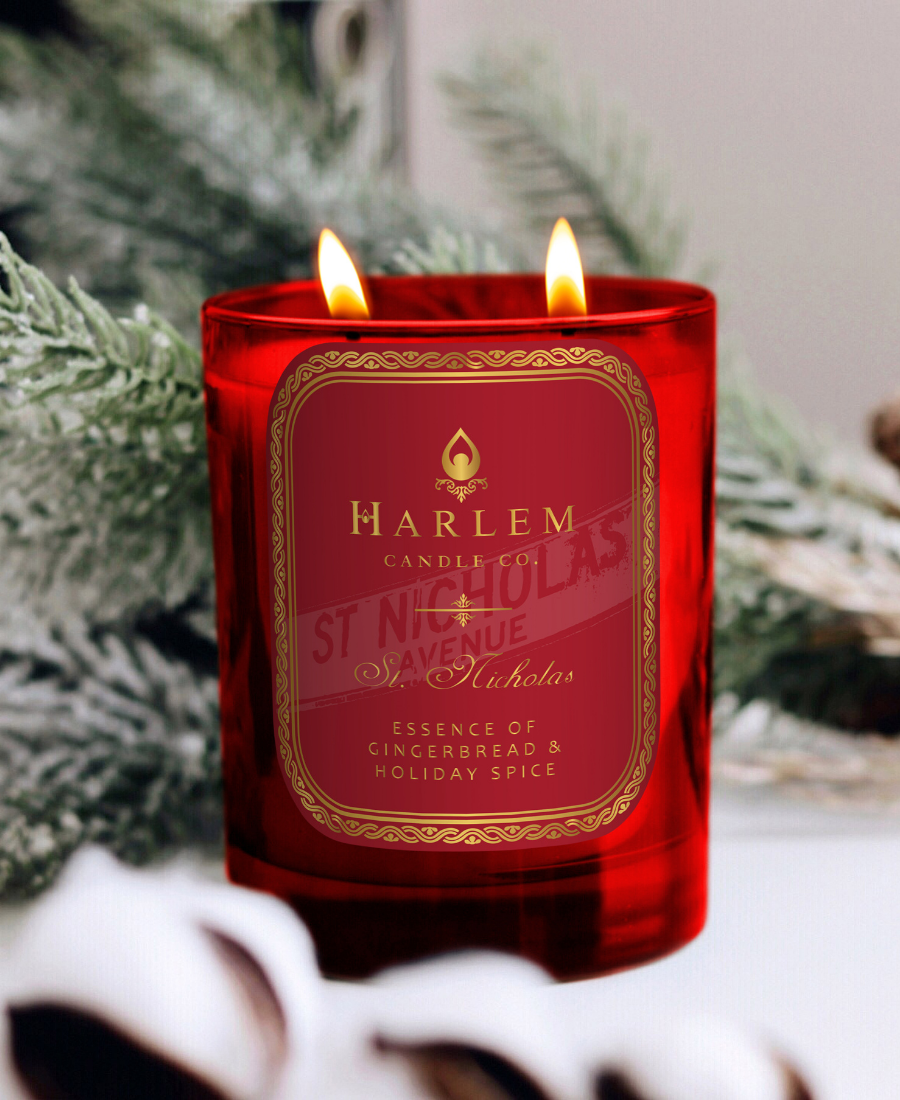 St. Nicholas candle on a white table with frosted greenery.
