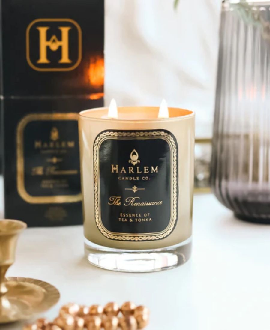 The Renaissance Candle on a white table with packaging and luxury items.