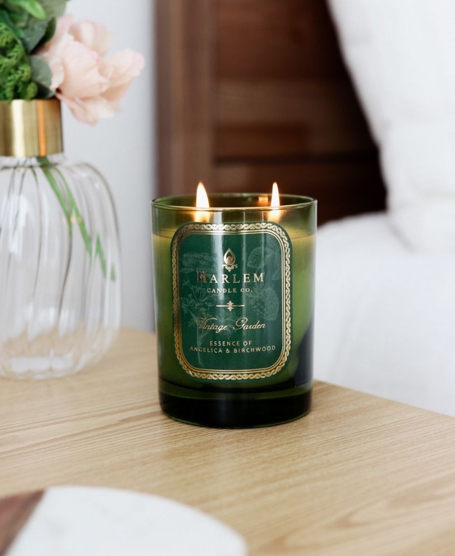 Vintage Garden Candle on a wooden table with flowers.