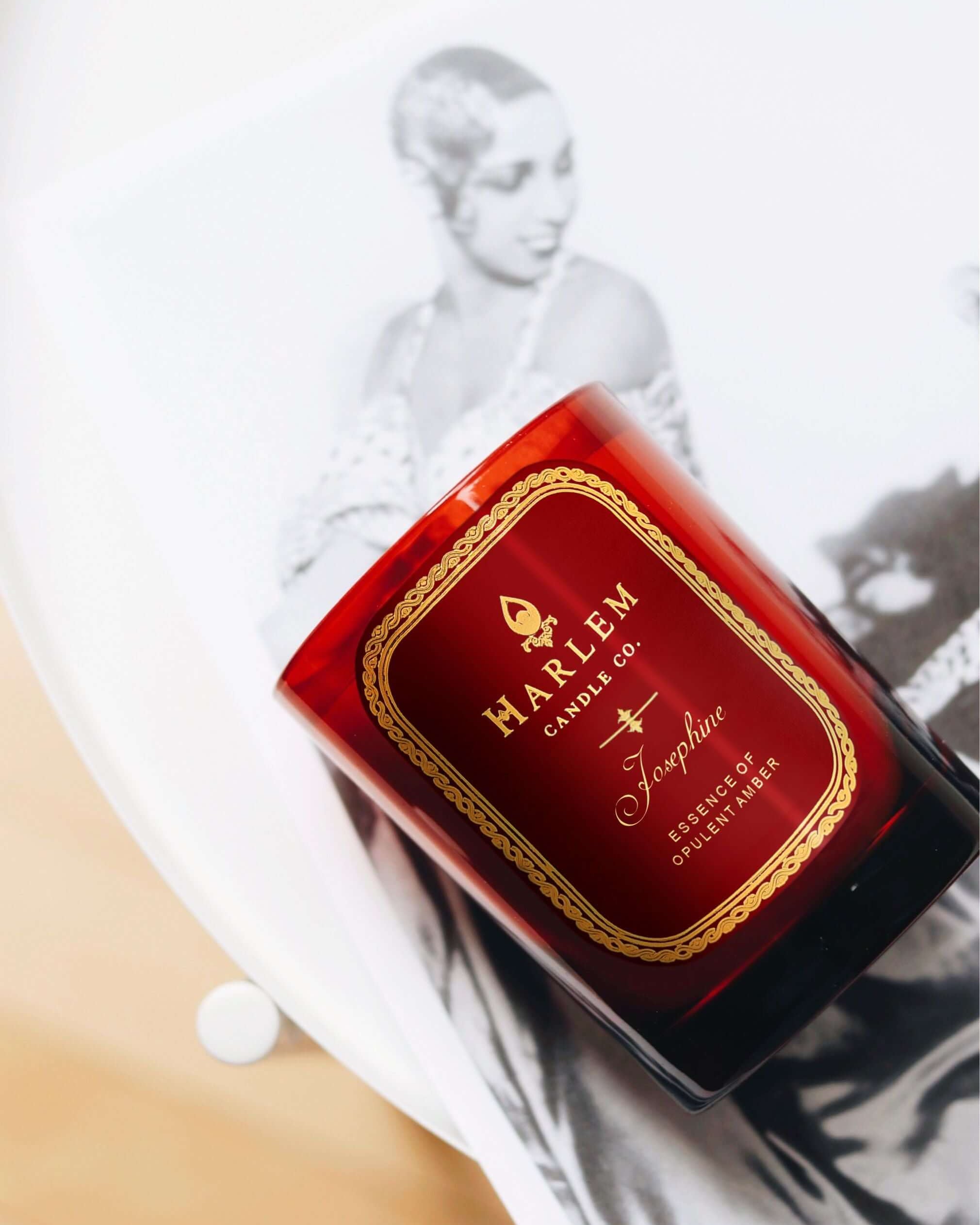 Lifestyle image of our Josephine Candle on top of a black and white image of Josephine Baker