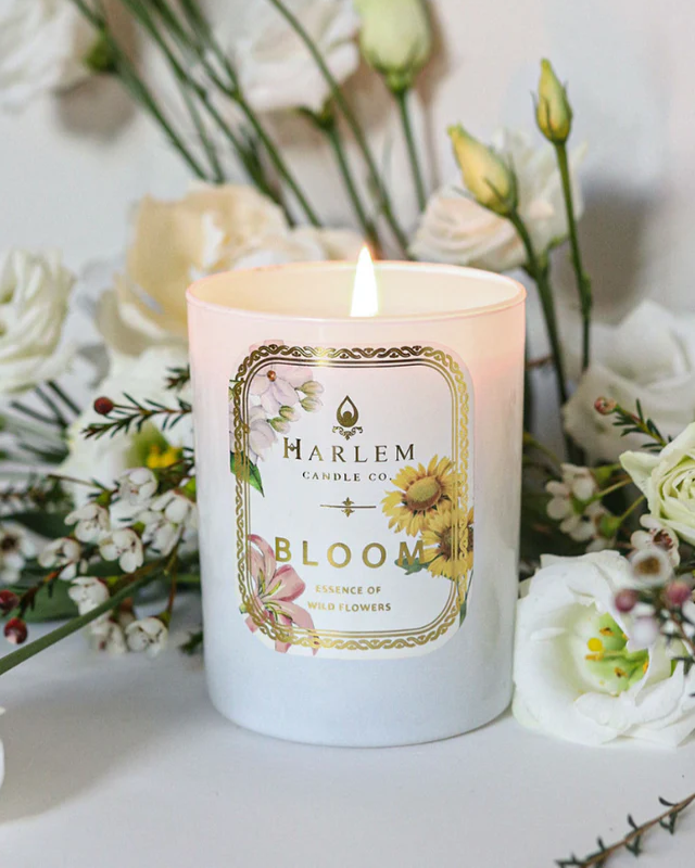 Candle with 'Harlem Candle Co'  Bloom label surrounded by flowers