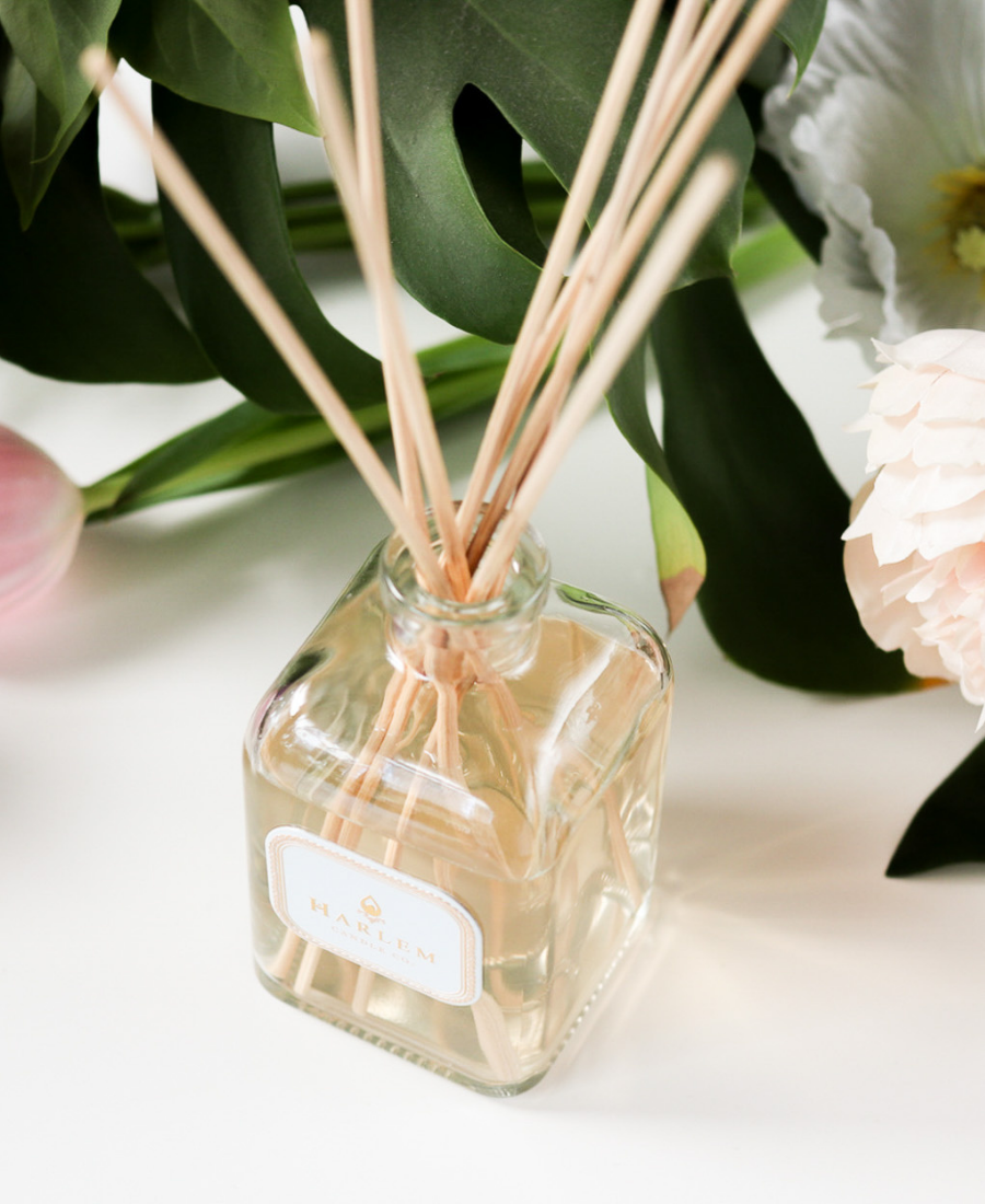 Joy Reed Diffuser on a white table with flowers.