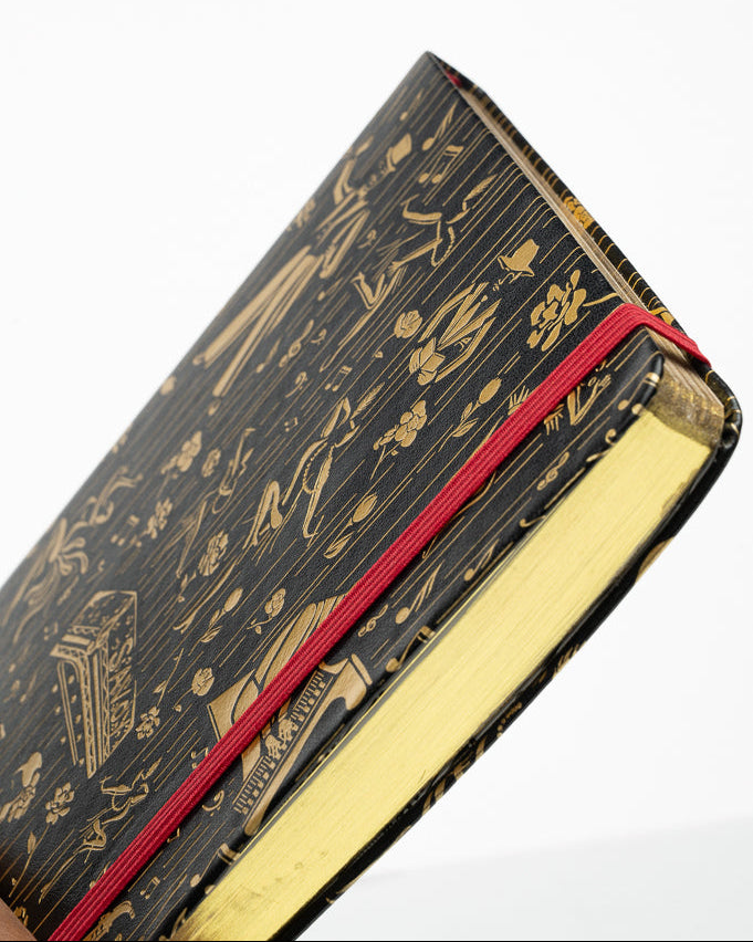 This is a image of the Harlem Renaissance inspired journal, showing the gold page edges and crimson elastic band.