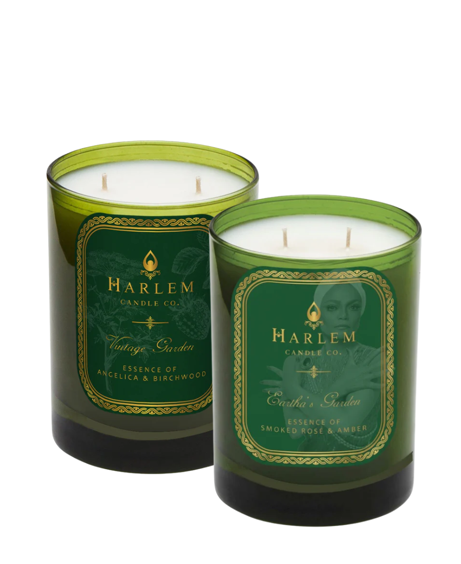 Two green candles with labels from Harlem Candle Co. on a white background