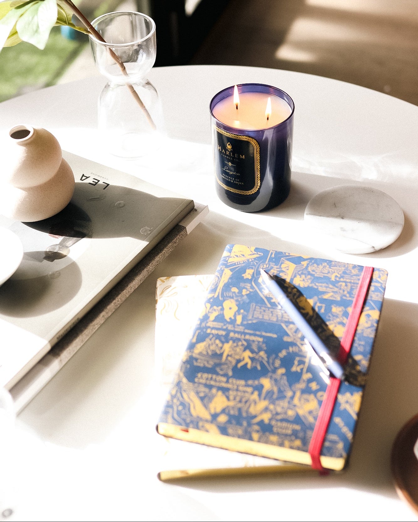This is an image of our nightclub map of Harlem, navy and gold journal pictured next to our Langston candle