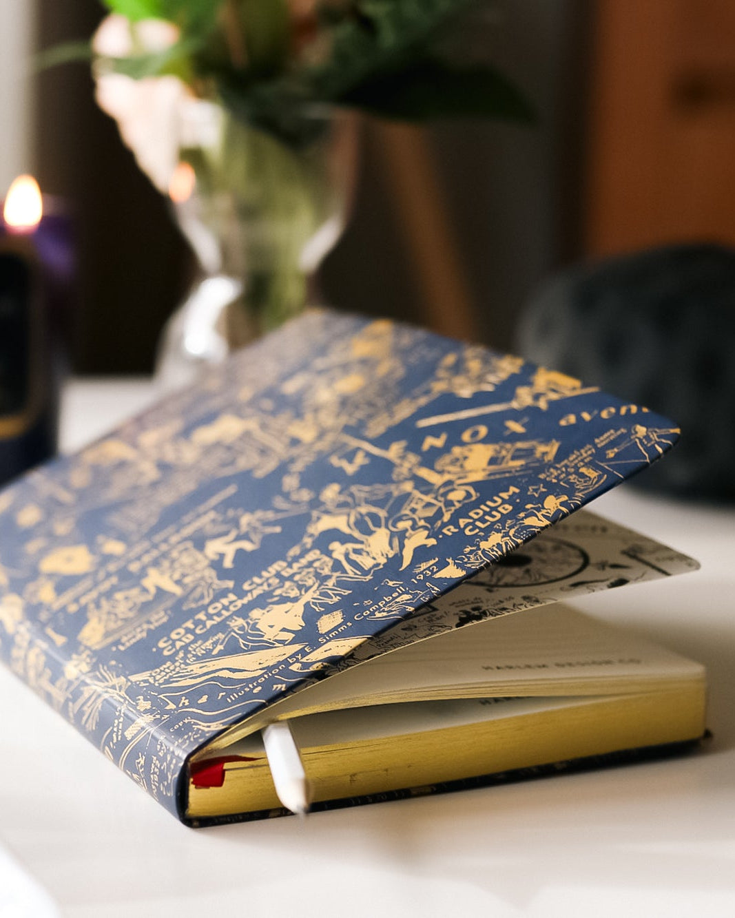 This is an image of our navy and gold nightclub map of Harlem journal featured next to our Langston candle with the flames illuminated