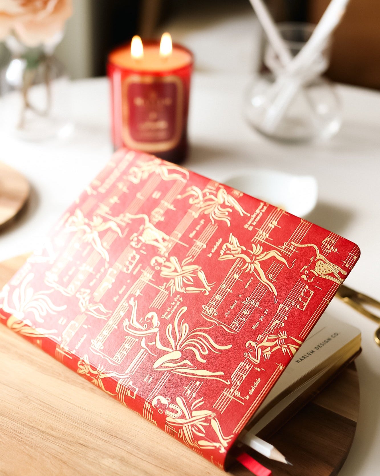 The red journal on a table with a pencil.