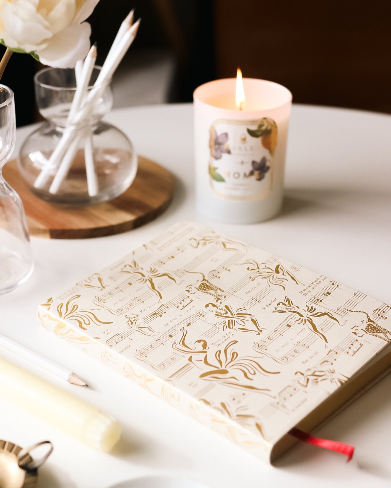 This is an image of our Josephine journal and cream and gold pictured next to our home candle with the flame illuminated.