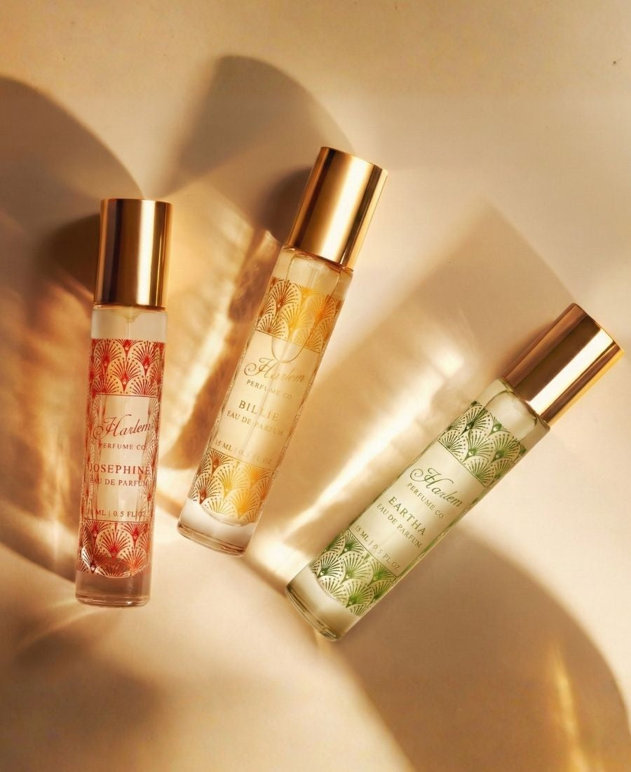 Three perfume bottles with gold caps on a beige background