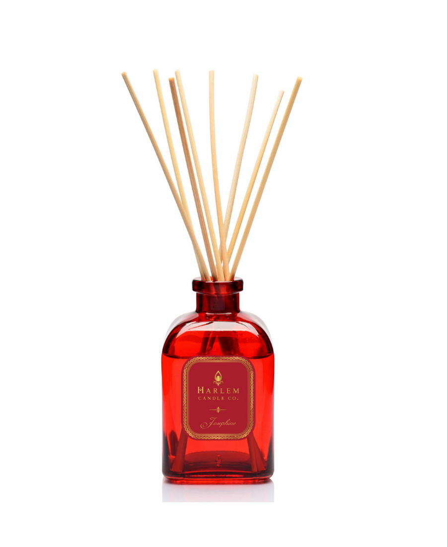 Josephine reed diffuser bottle with multiple natural wood reed sticks rising above the top, set against a plain white background.