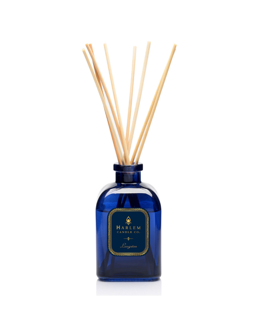 Langston reed diffuser bottle with multiple natural wood reed sticks rising above the top, set against a plain white background.