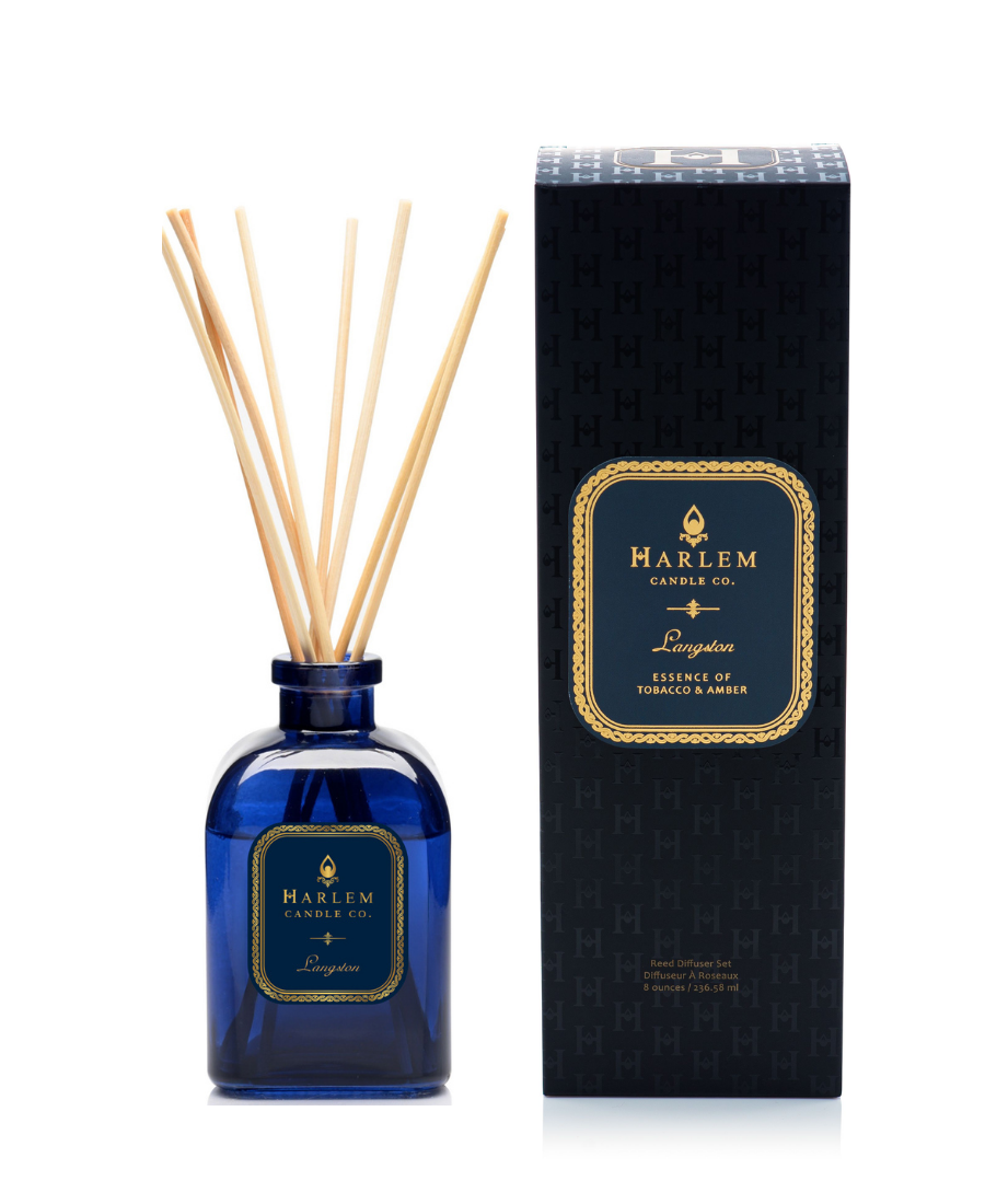 Langston reed diffuser bottle with natural reeds next to its black textured packaging box on a white background.