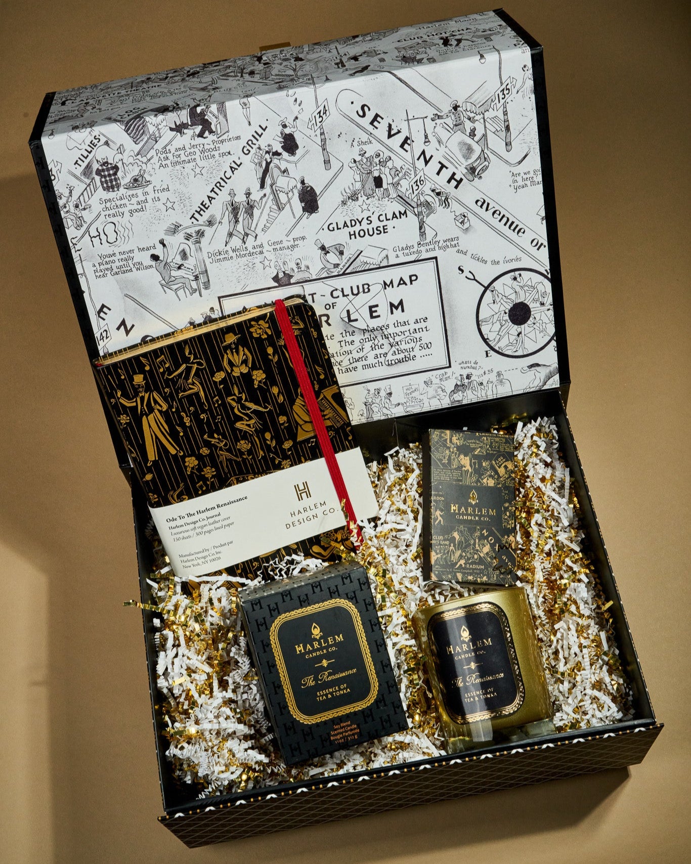 This is an image of our Renaissance stories gift box which include an 11 ounce Renaissance candle, our ode to the Harlem Renaissance, black and gold journal, and our black and gold nightclub map of Harlem, elegant matches.