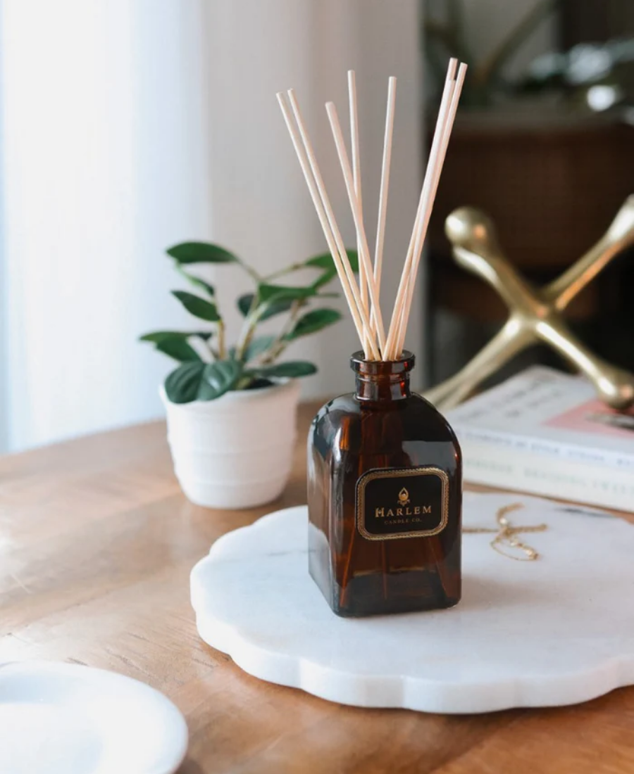 Savoy Reed Diffuser on a marble tray with books, greenery, jewelry, and a gold paperweight.