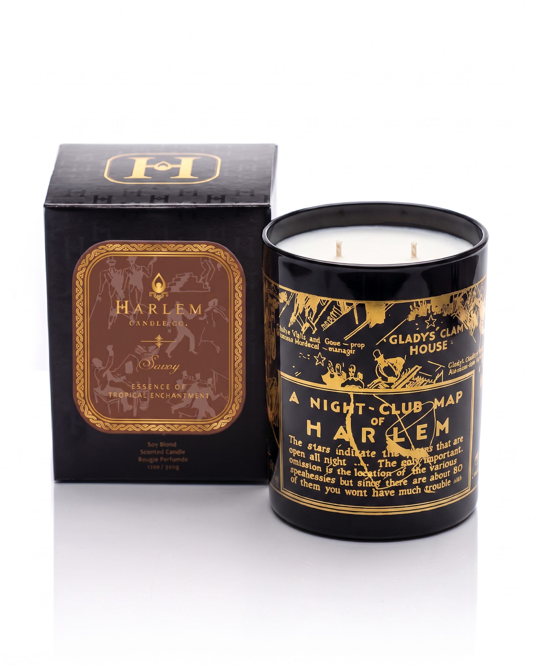 Our stunning 22K Gold Cocktail Glass Savoy 12 oz candle scents of ozone, cassis and mandarin scented candle sitting next to its decorative box on a white background. 