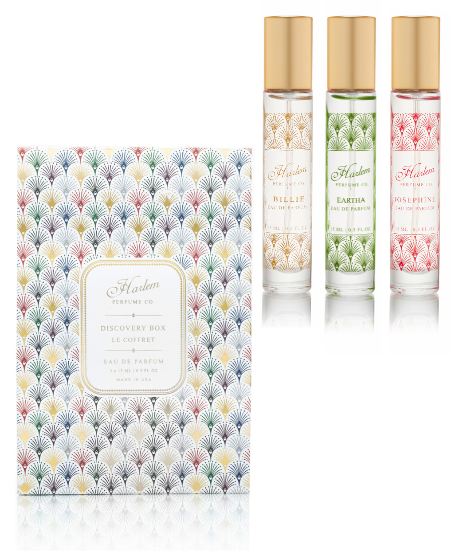 Three perfume bottles with floral designs and a patterned box on a white background