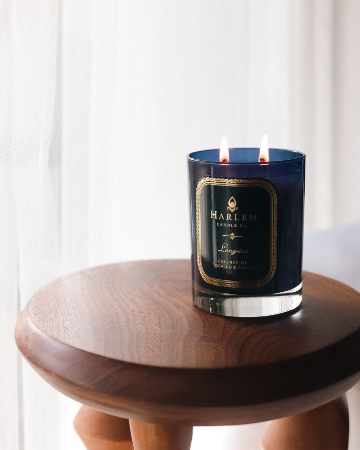 Our 11oz Langston Candle sitting on a wooden table. 